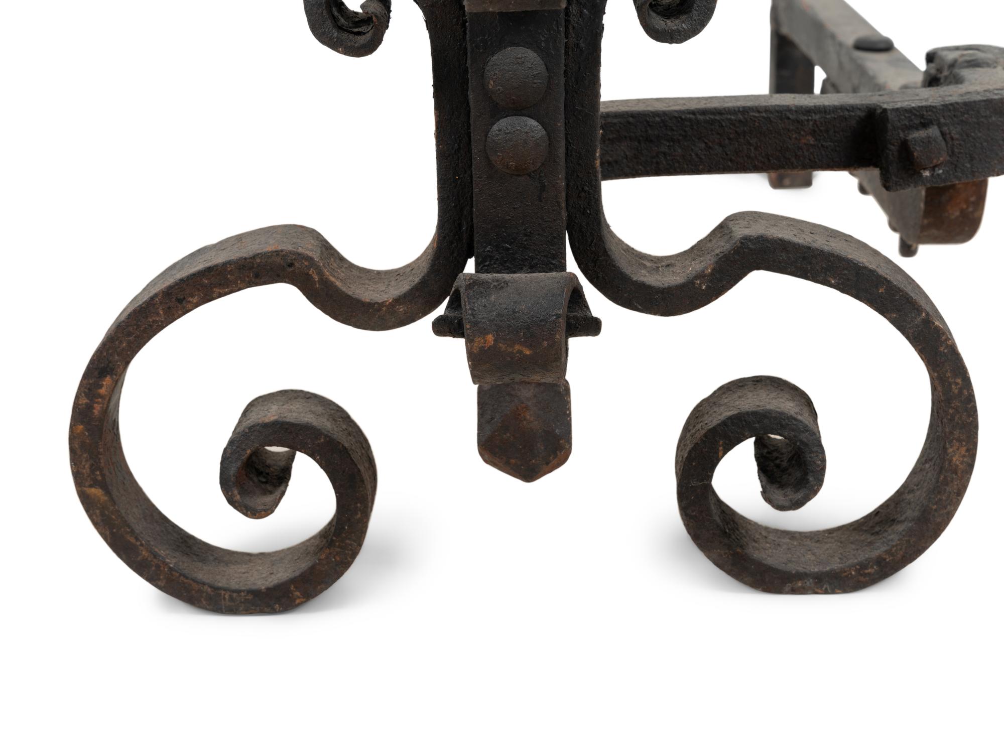 A Pair of Continental Iron Andirons with Posset Cup Holders