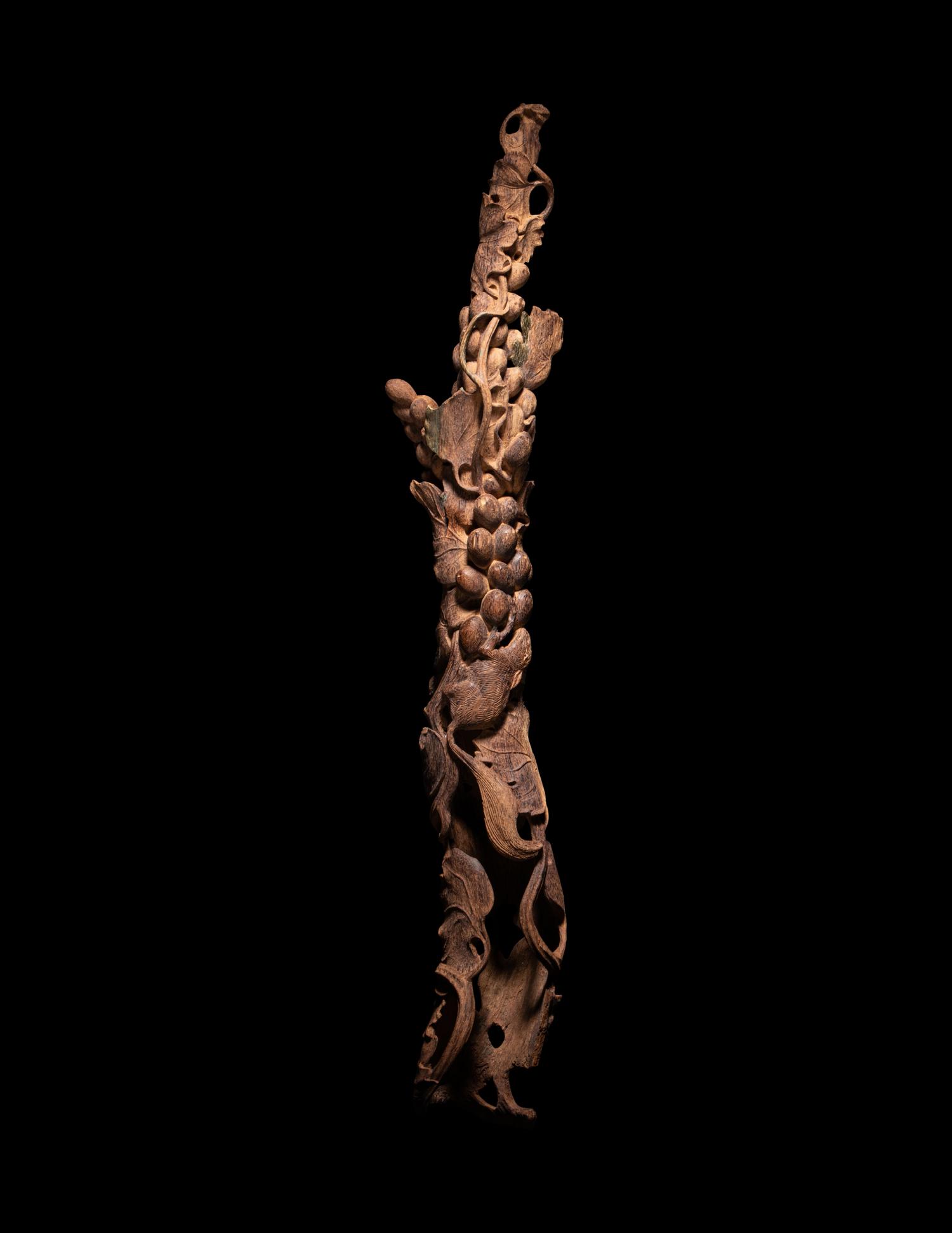 A Chinese Chenxiang Wood 'Squirrel and Grapes' Carving