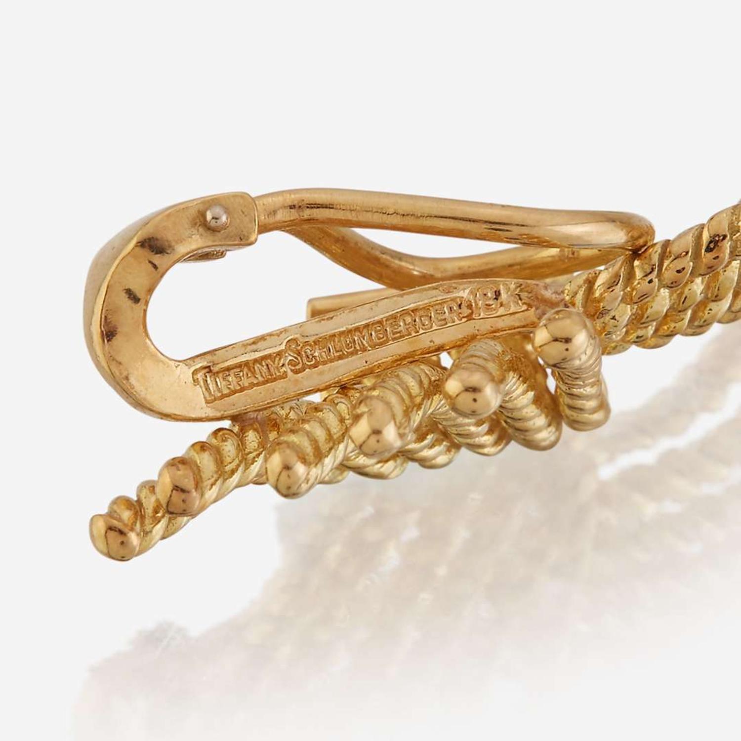 A pair of eighteen karat gold ear clips and a sterling silver and eighteen karat gold brooch, Tiffany & Co.