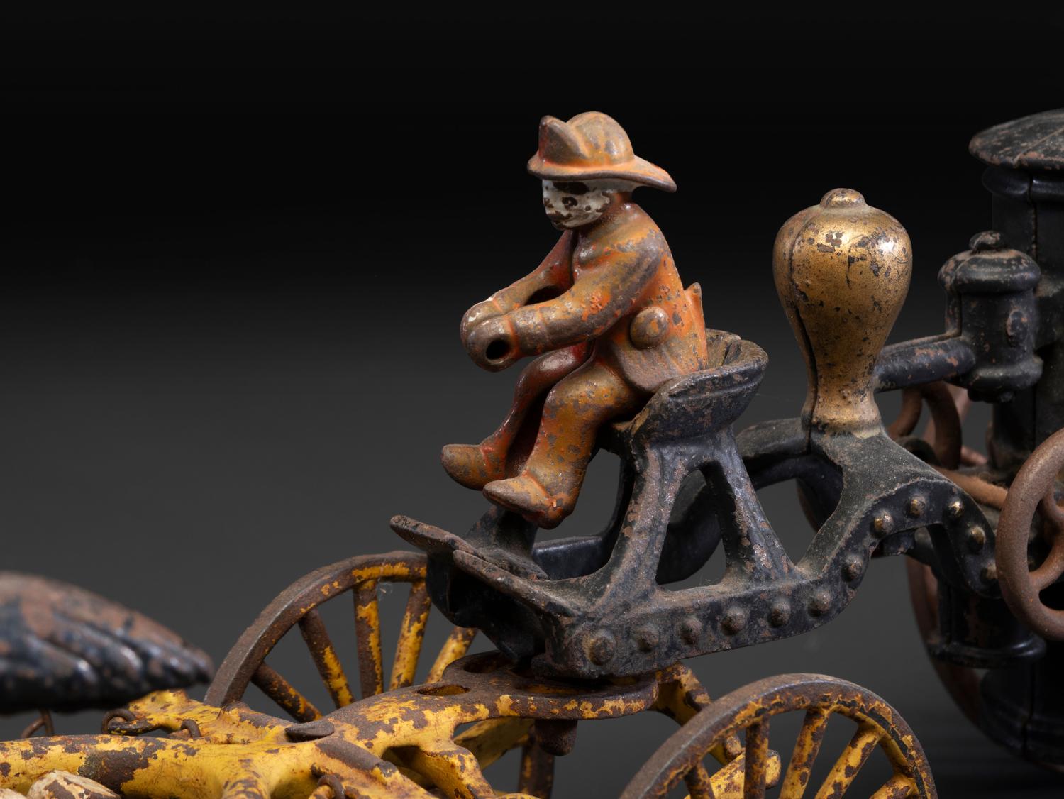 A Painted Cast Iron Three-Horse Fire Pump Wagon Toy