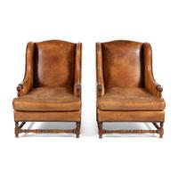 A Pair of Louis XIII Style Oak and Leather Wingback Armchairs