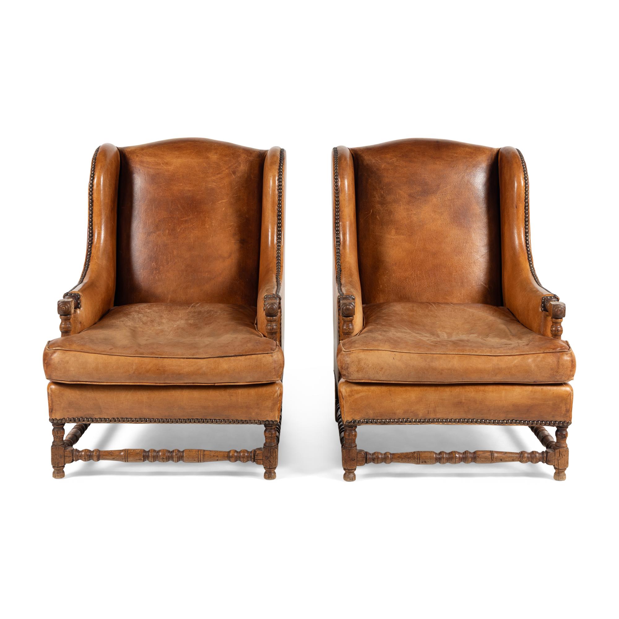 A Pair of Louis XIII Style Oak and Leather Wingback Armchairs