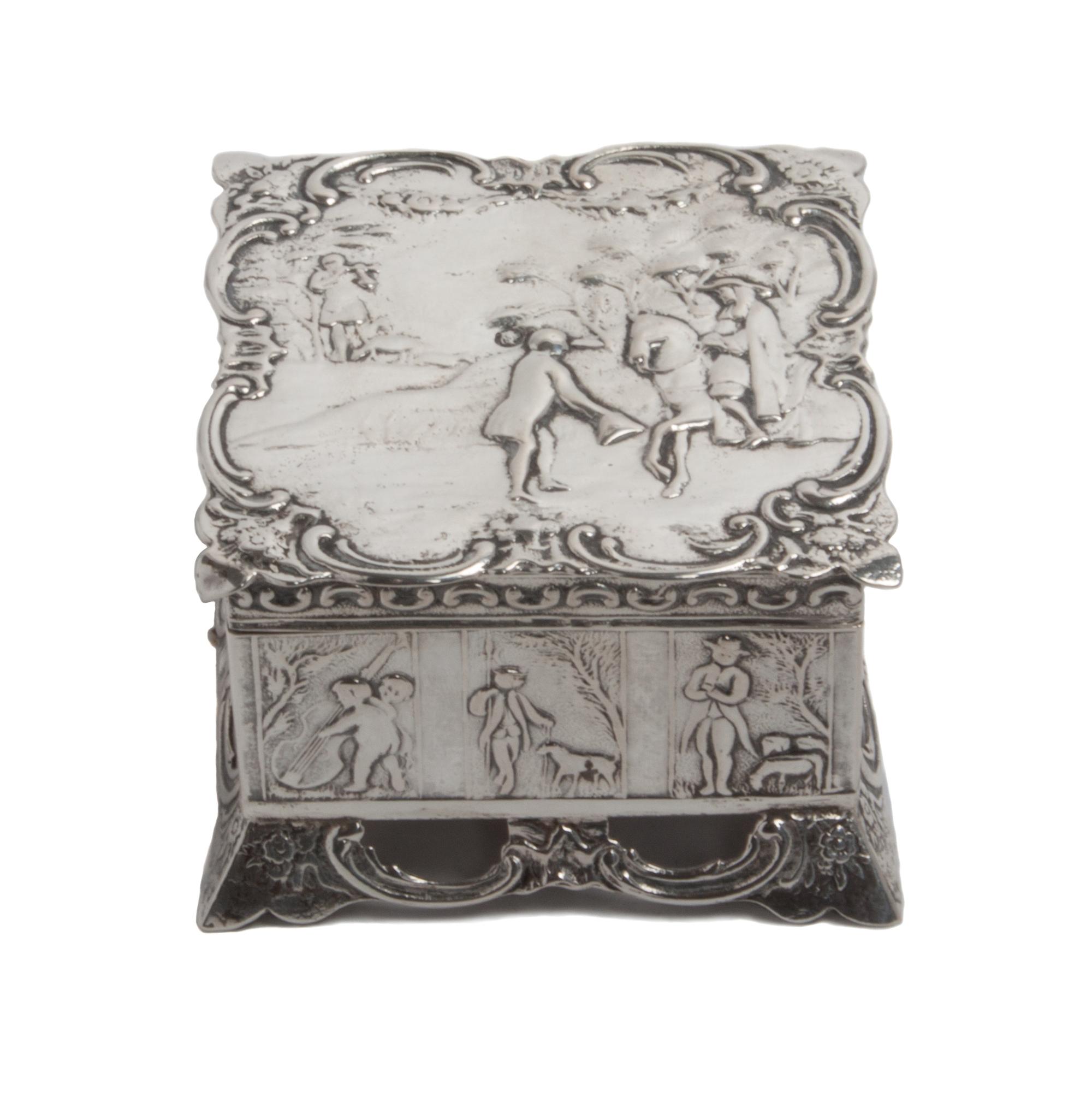 A Dutch Silver Box, , of square form, having allover chased designs, the hinged lid depicting a landscape with a figure on horseback wi