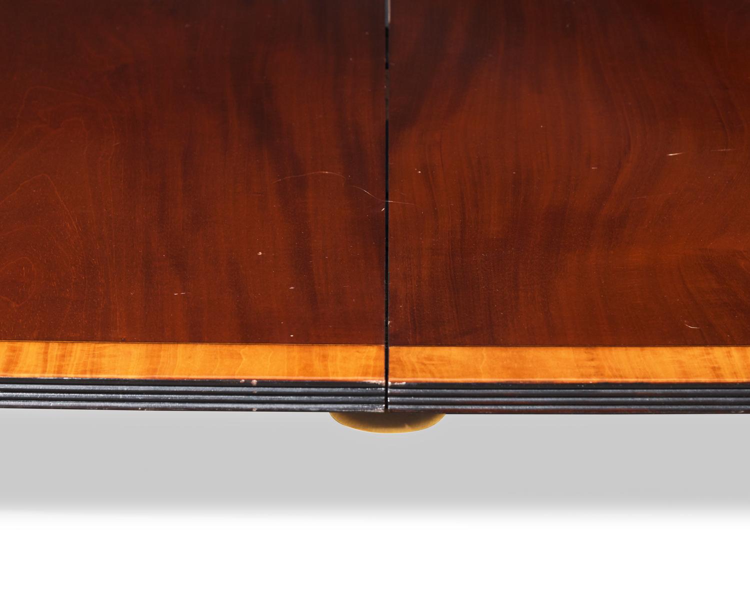 A Regency style two-pedestal inlaid mahogany and satinwood dining table, 20th century