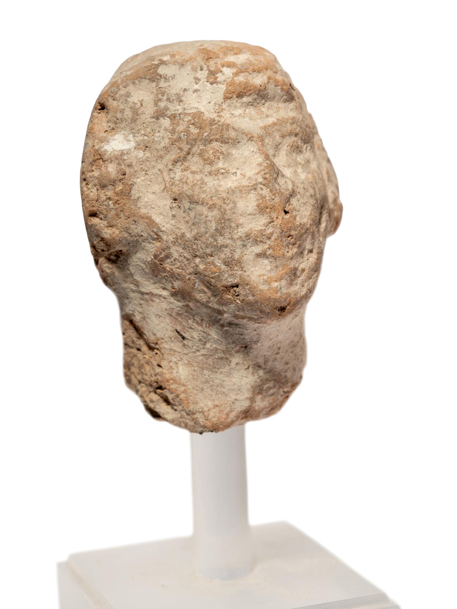 A Near Eastern Terracotta Figure and a Head