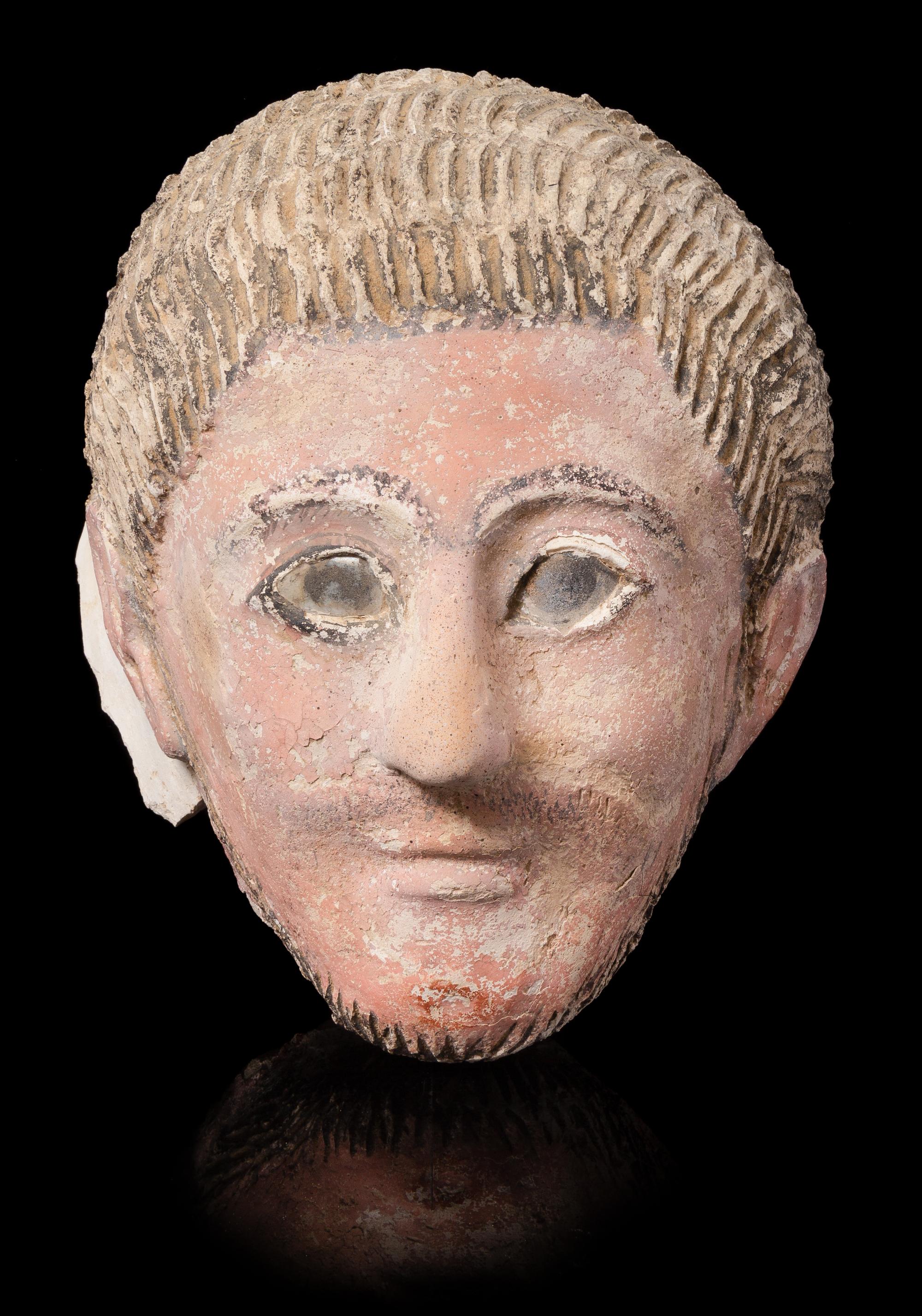 A Romano-Egyptian Plaster Mummy Mask Height 9 1/2 inches. — CIRCA 2ND CENTURY C.E.