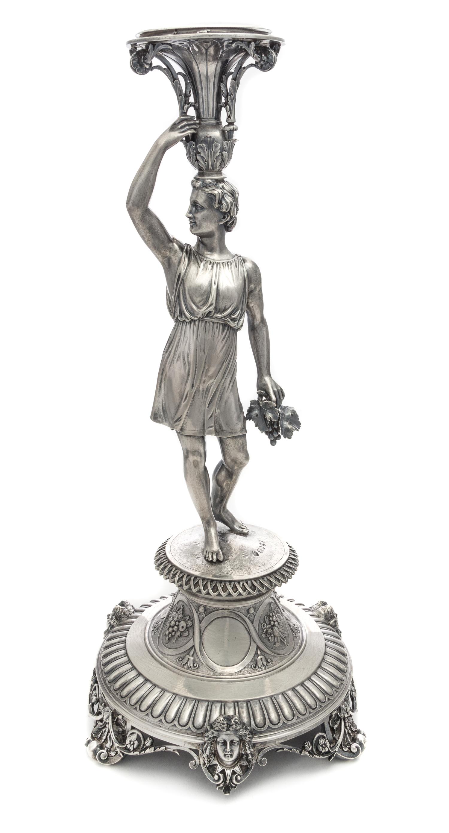 A Victorian Silver Centerpiece, Edward Barnard & Sons, London, 1871, the atlantid stem holding a grape bunch in one hand and balancing