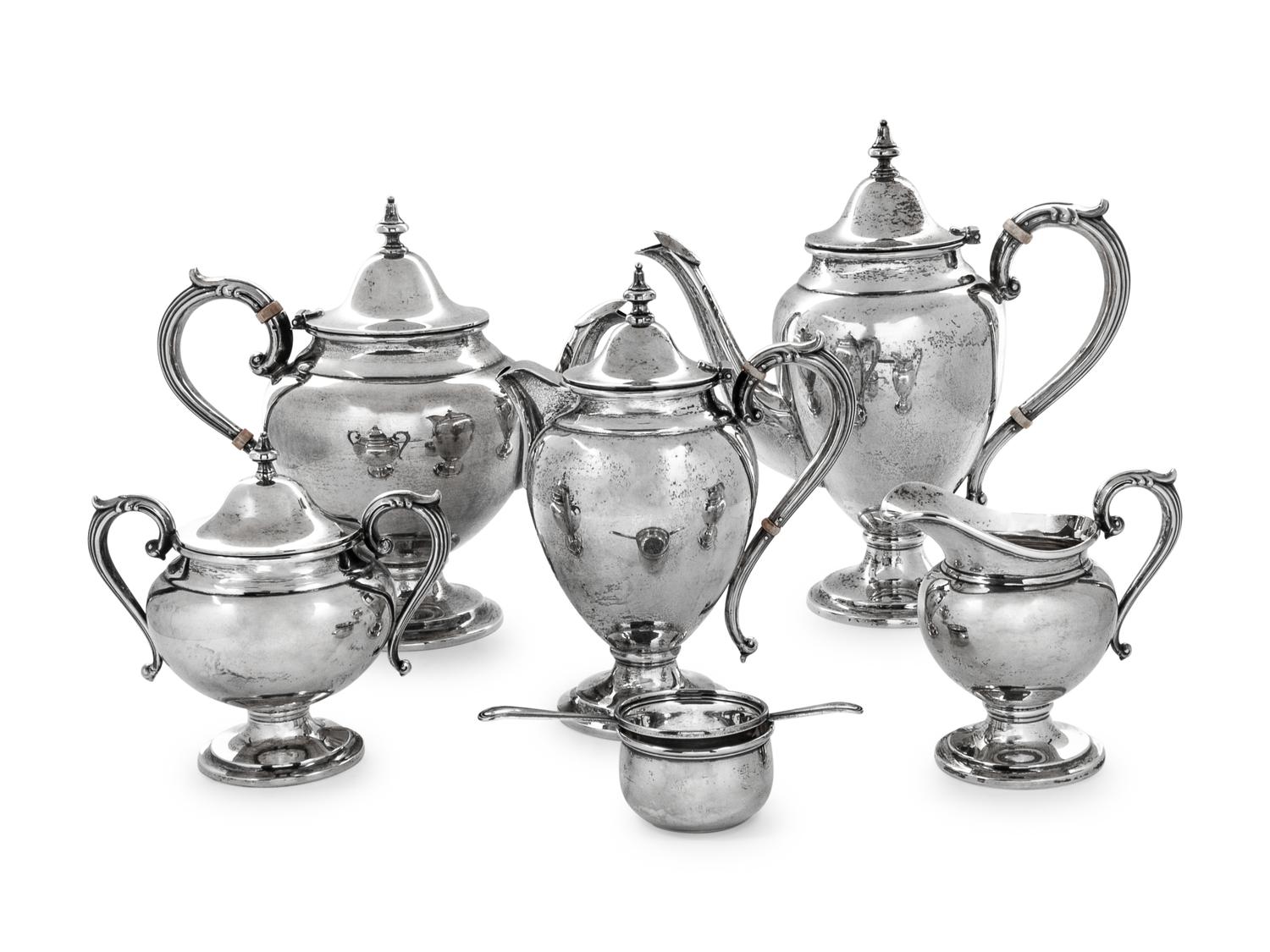 comprising a coffee pot, teapot, chocolate pot, creamer, covered sugar, tea strainer and cup, 7 items total.