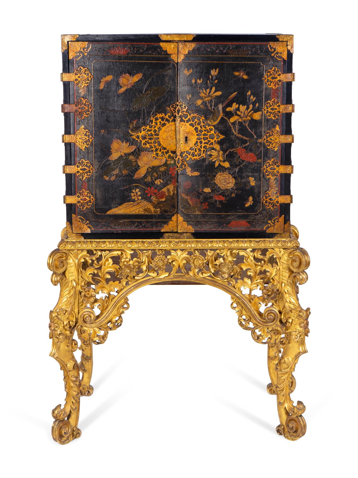 A Chinese Brass-Mounted Gilt-Decorated Black Lacquer Cabinet on Later Giltwood Stand — 18TH/19TH CENTURY