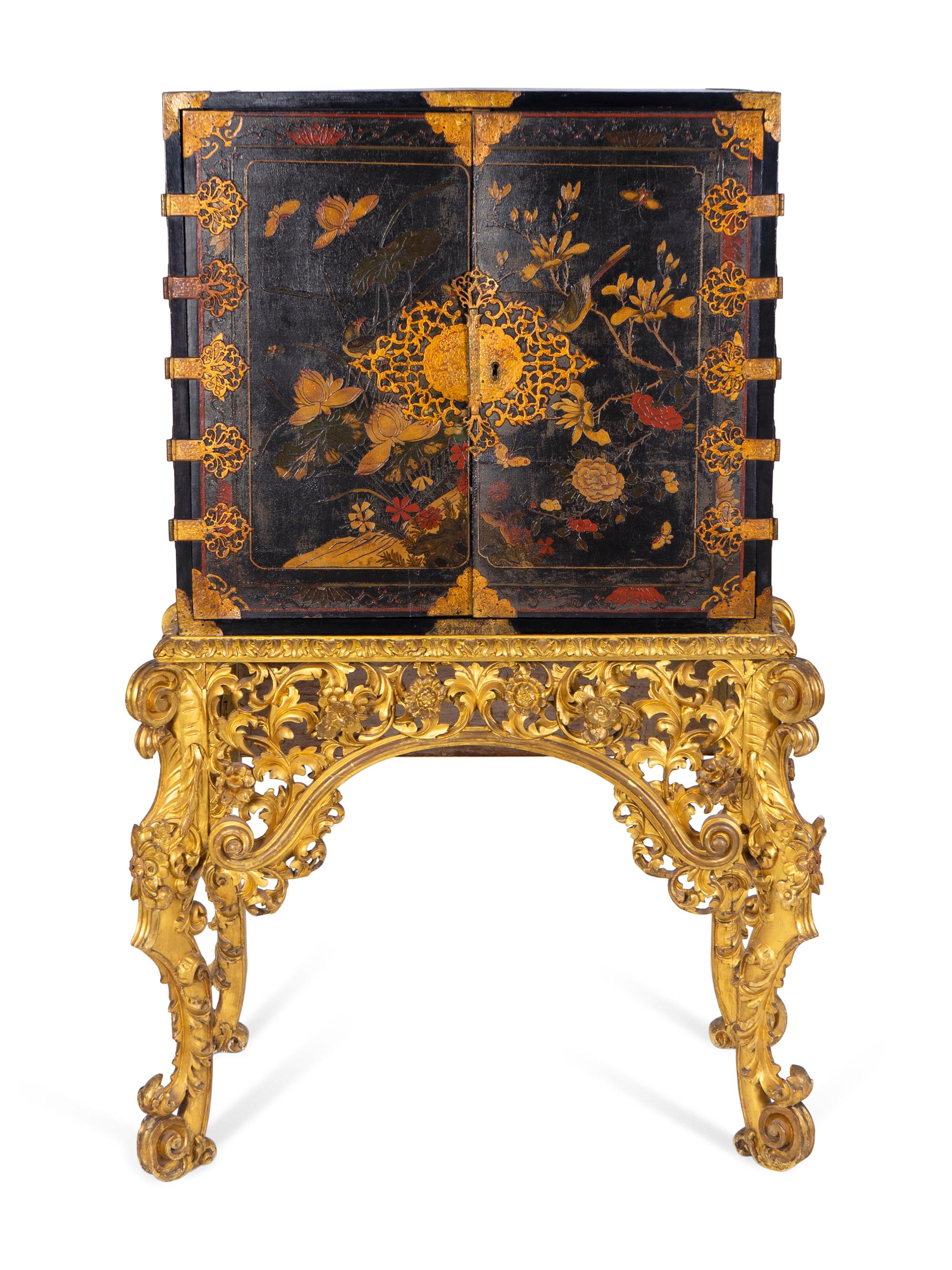 A Chinese Brass-Mounted Gilt-Decorated Black Lacquer Cabinet on Later Giltwood Stand — 18TH/19TH CENTURY