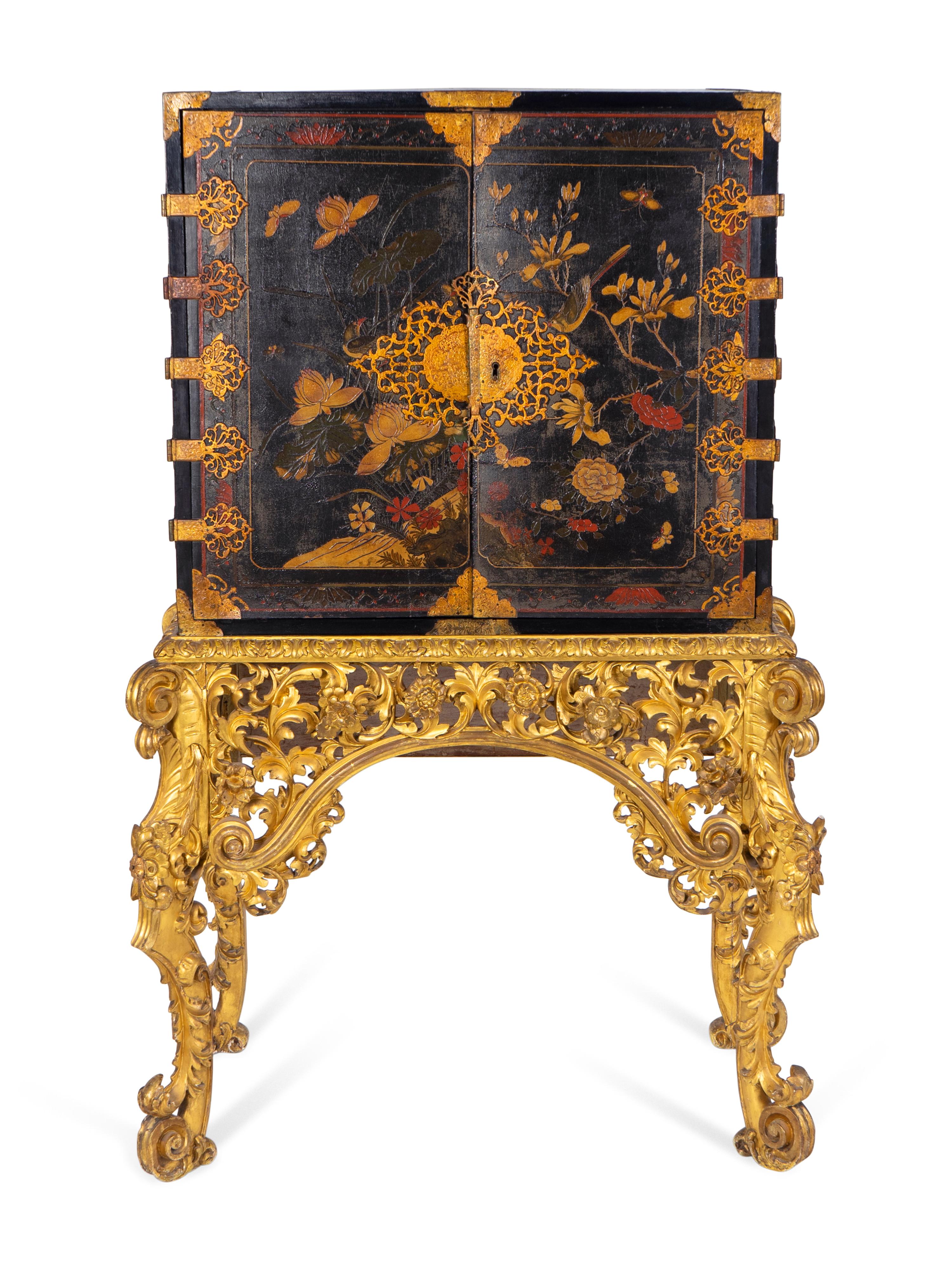 A Chinese Brass-Mounted Gilt-Decorated Black Lacquer Cabinet on Later Giltwood Stand — 18TH/19TH CENTURY