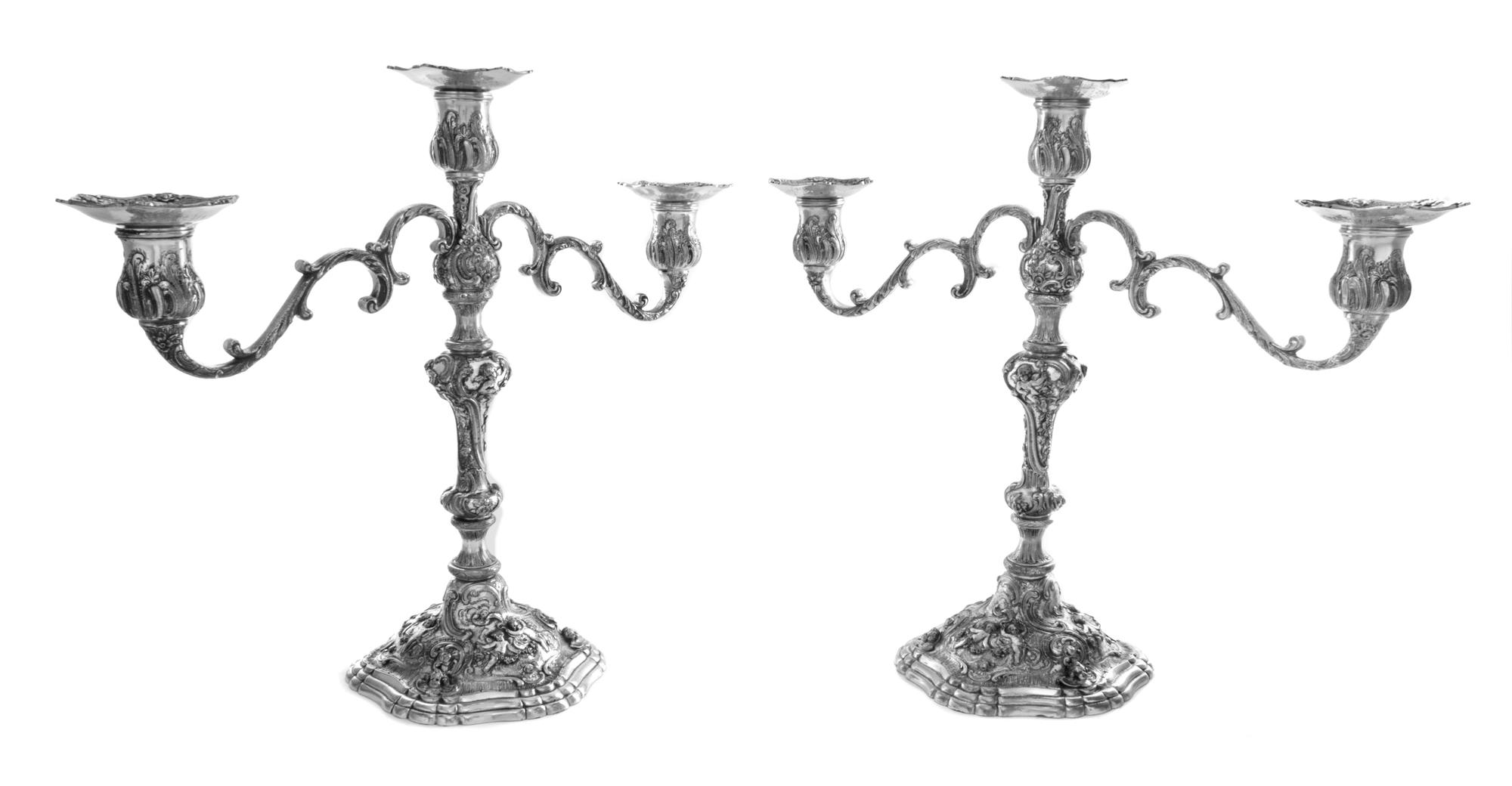 A Pair of American Silver Three-Light Candelabra, Marshall Field & Co., Chicago, IL, worked to show C-scroll, floral, foliate and putti