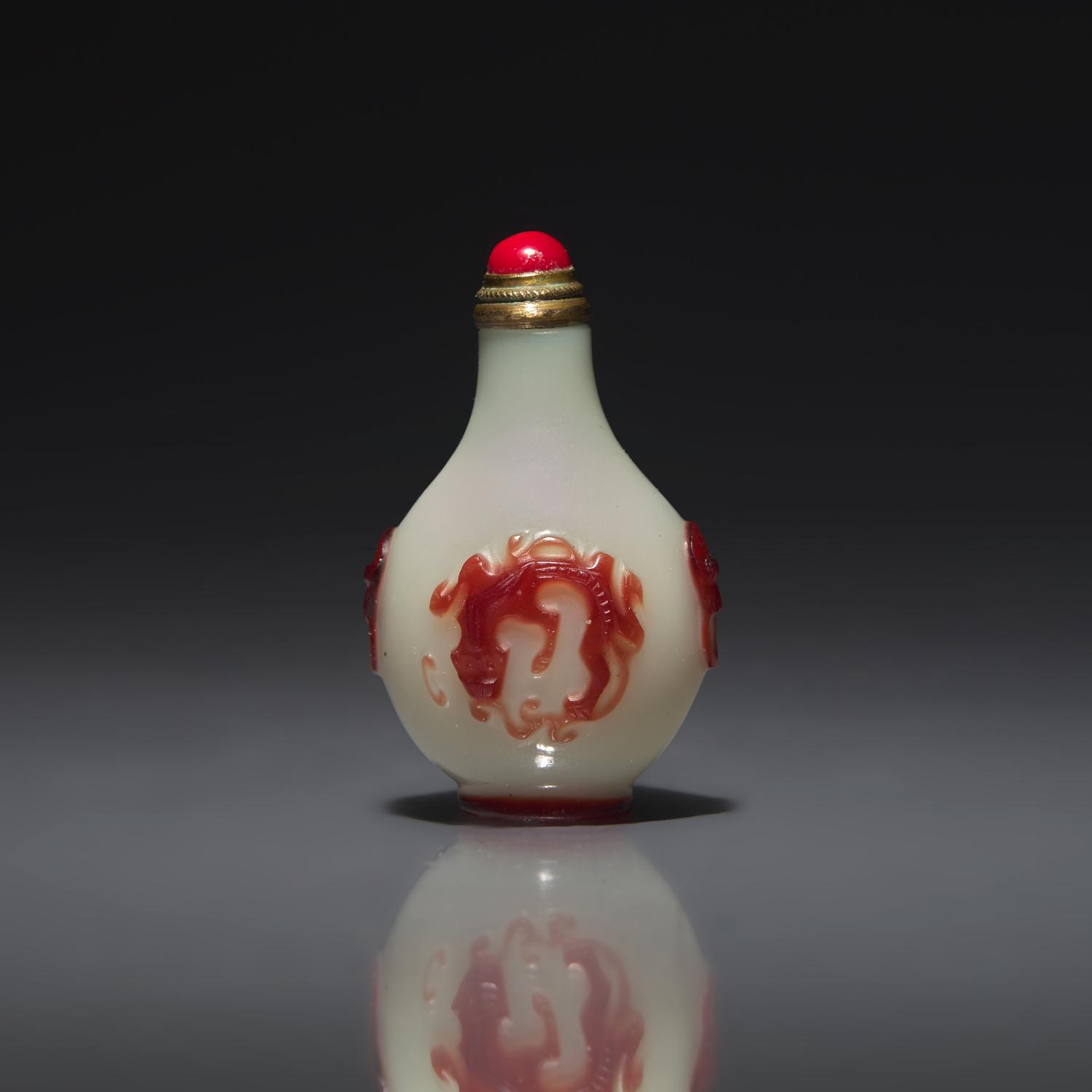 A Chinese Miniature Red-Overlaid Opaline Glass Snuff Bottle, Circa 1750-1820 1750-1820年 涅白地套寶石紅料螭龍紋小鼻烟壺