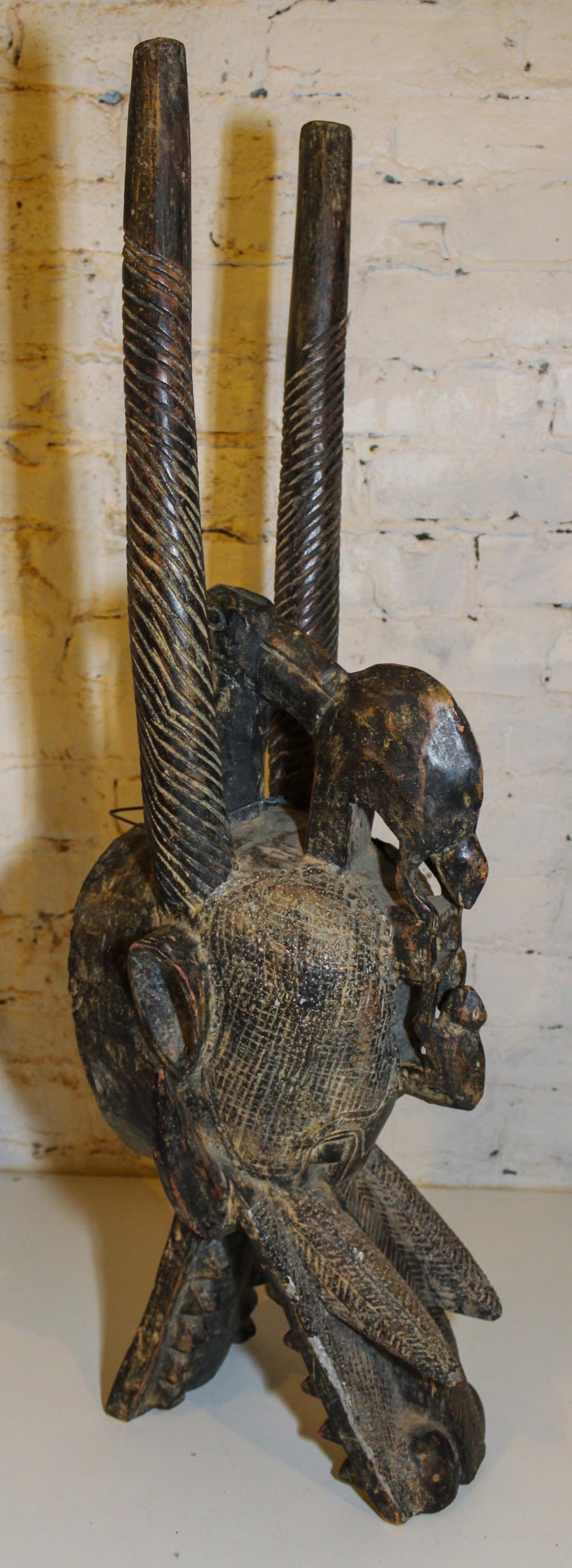 A Senufo Wood and Patinated Metal "Firespitter" Mask Height 35 1/2 inches.