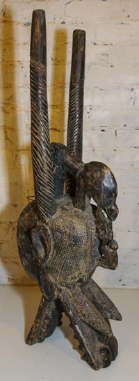 A Senufo Wood and Patinated Metal "Firespitter" Mask Height 35 1/2 inches.