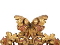 An Italian Rococo Style Red and Parcel Gilt Carved Wood Mirror