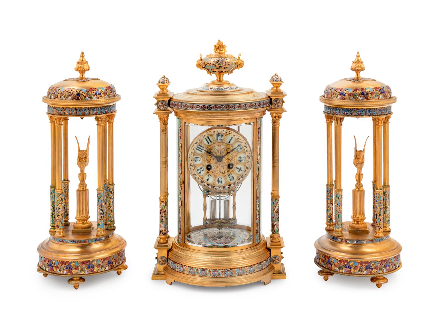 A Continental Enameled Gilt Metal Crystal Regulator Clock Garniture