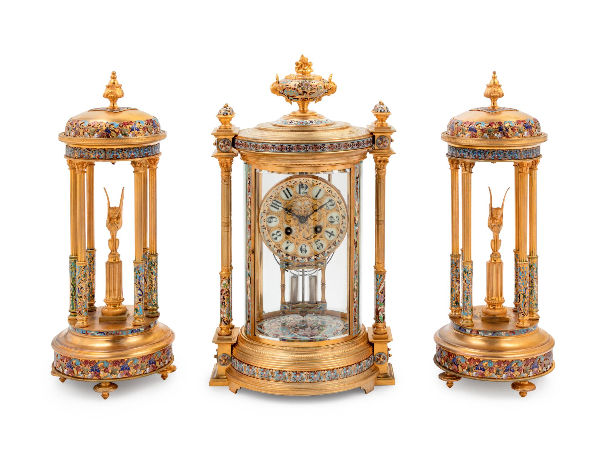 A Continental Enameled Gilt Metal Crystal Regulator Clock Garniture