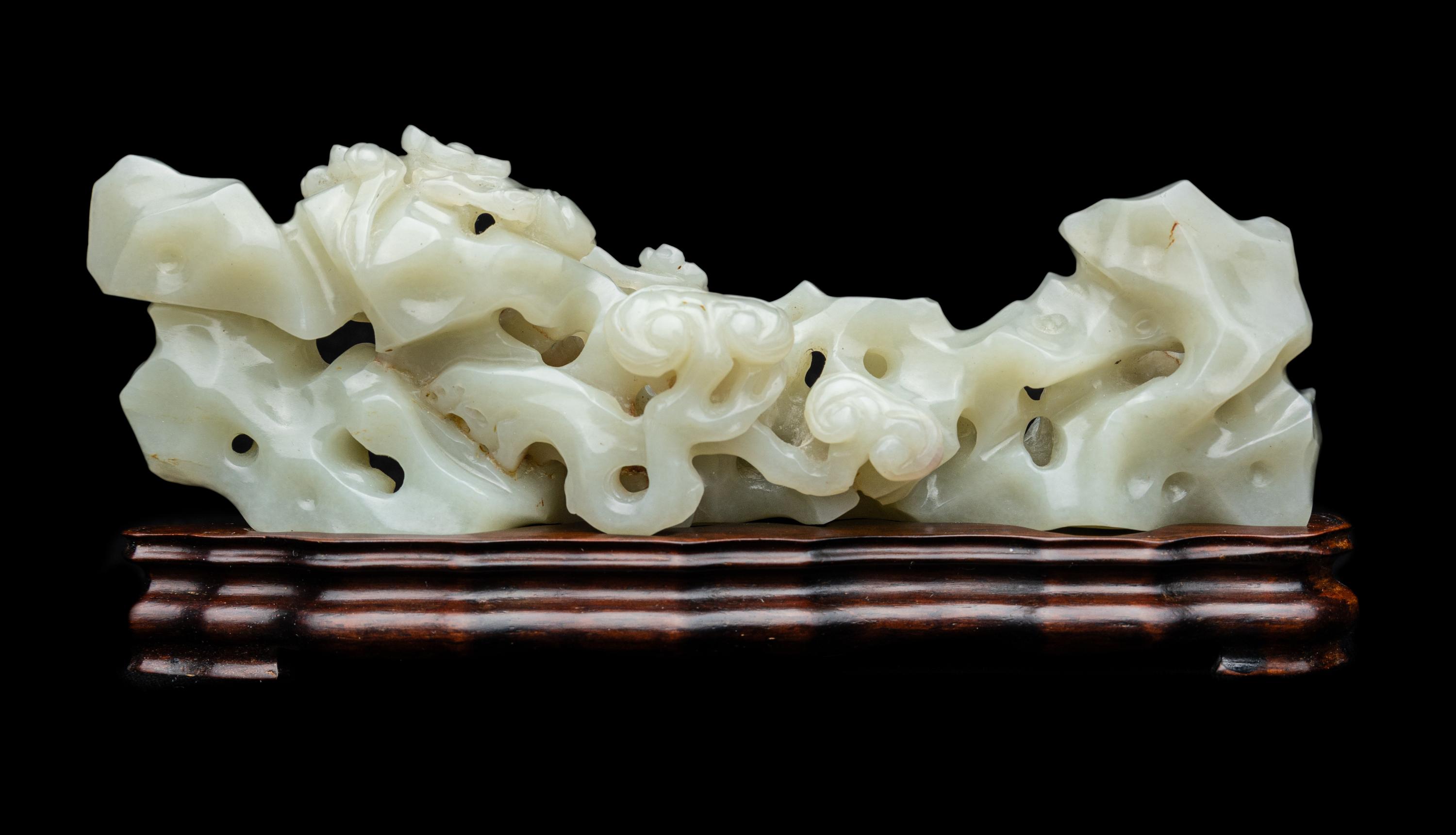 A Chinese Pale Celadon Jade ‘Lingzhi and Rockwork’ Brush Rest, 20th Century — 近代 青白玉靈芝筆架