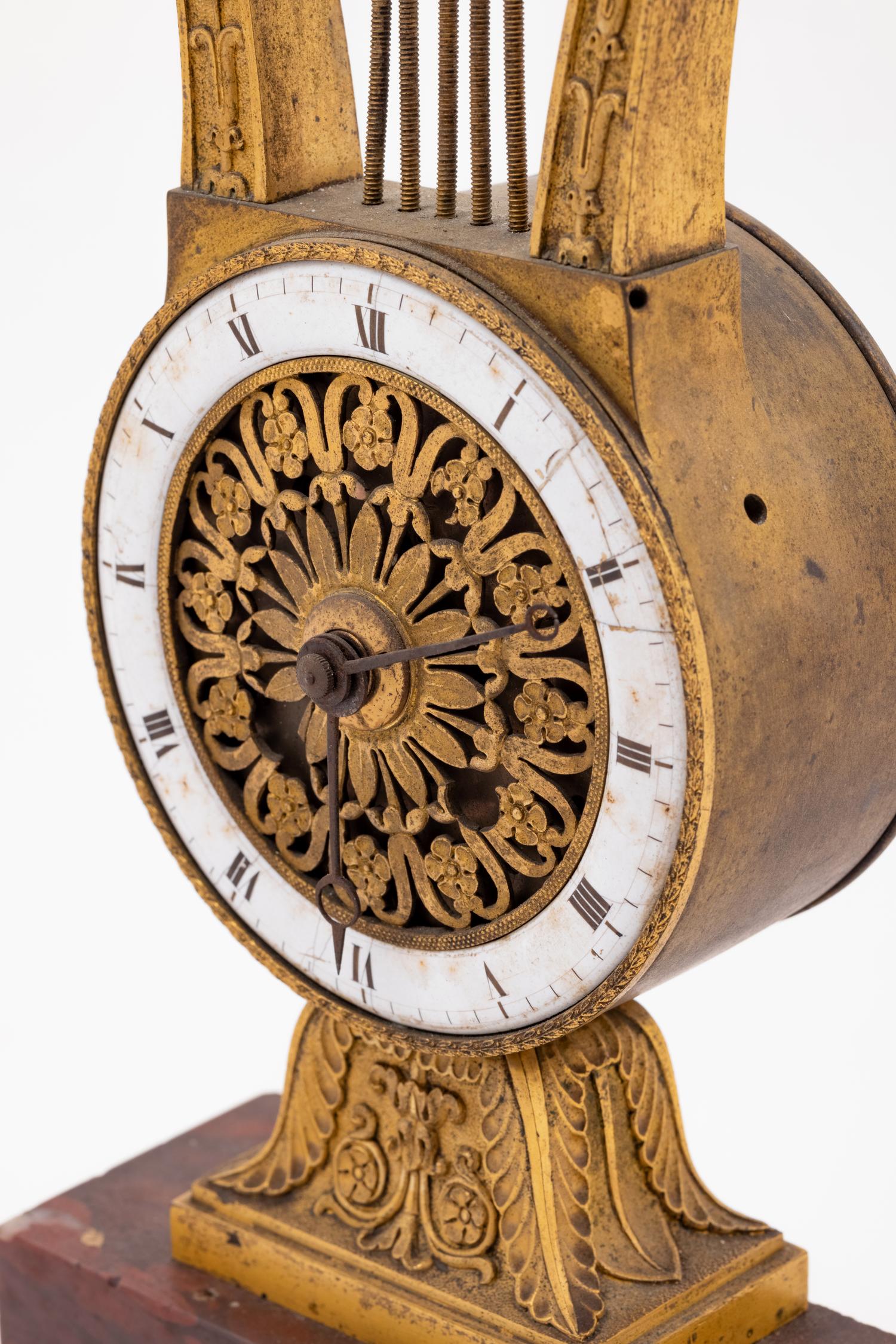 An Empire Style Gilt Bronze and Rouge Marble Clock