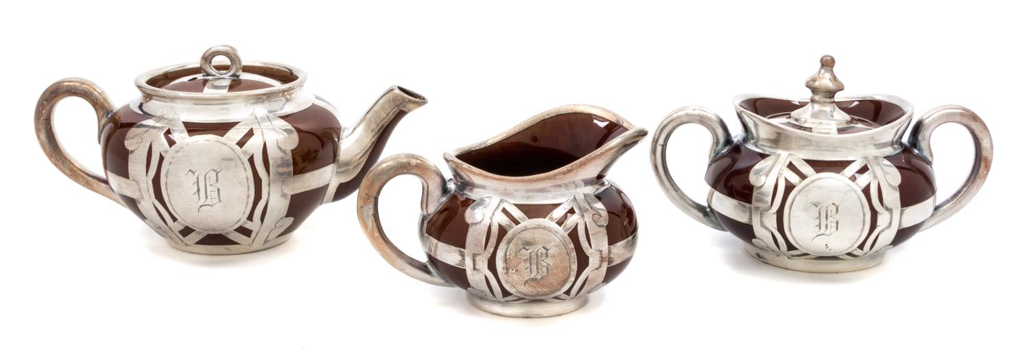 A Ceramic Silver Overlay Dimunitive Tea Service Width of teapot 6 1/2 inches.