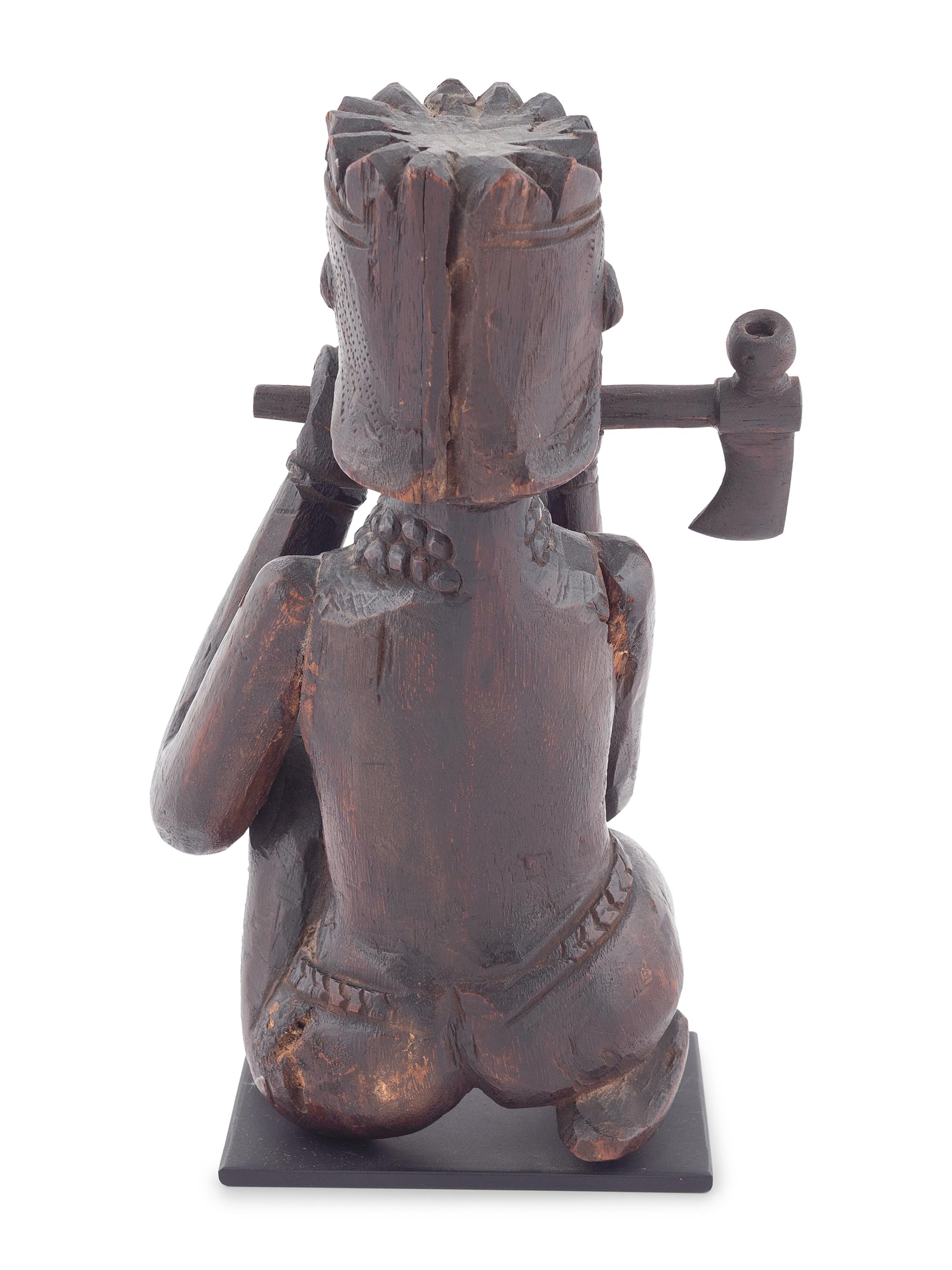 A Seated Folk Art Carved Walnut Indian with Tomahawk