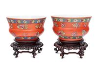 A Pair of Chinese Coral Red Ground Porcelain Cache Pots with Wood Stands