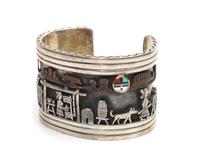 A Navajo Silver and 14 Karat Yellow Gold Storyteller Bracelet, Clarence Lee Length 4 3/4 x opening 1 1/8 x width 1 1/2 inches.