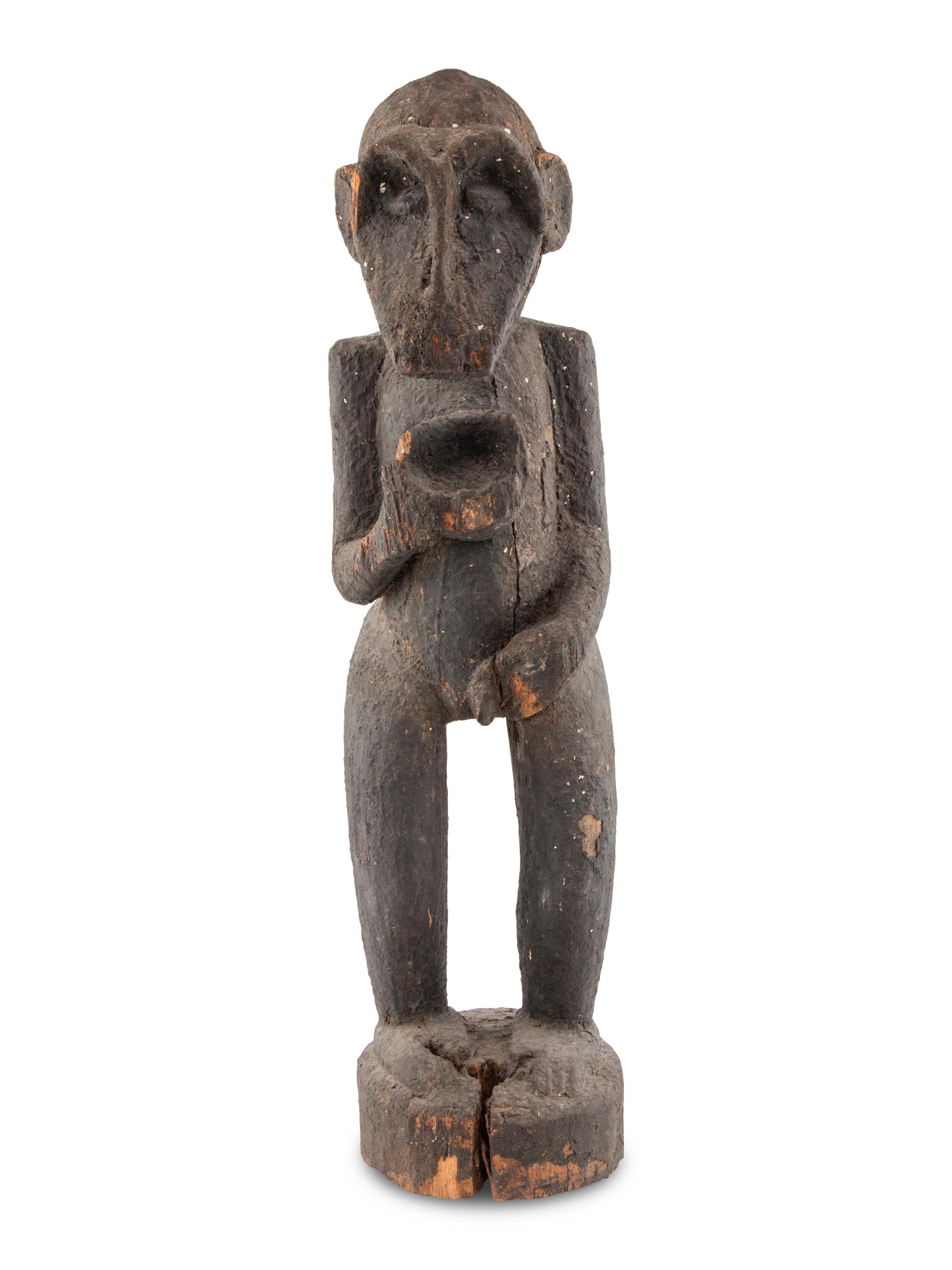A Carved Wood and Black Painted Monkey Figure