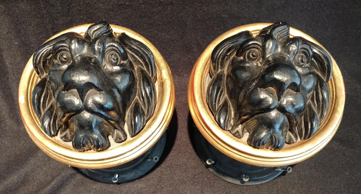 A Pair of Black Composition Lion's Head Stays Diameter 7 inches.
