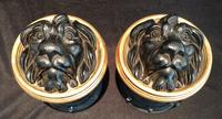 A Pair of Black Composition Lion's Head Stays Diameter 7 inches.