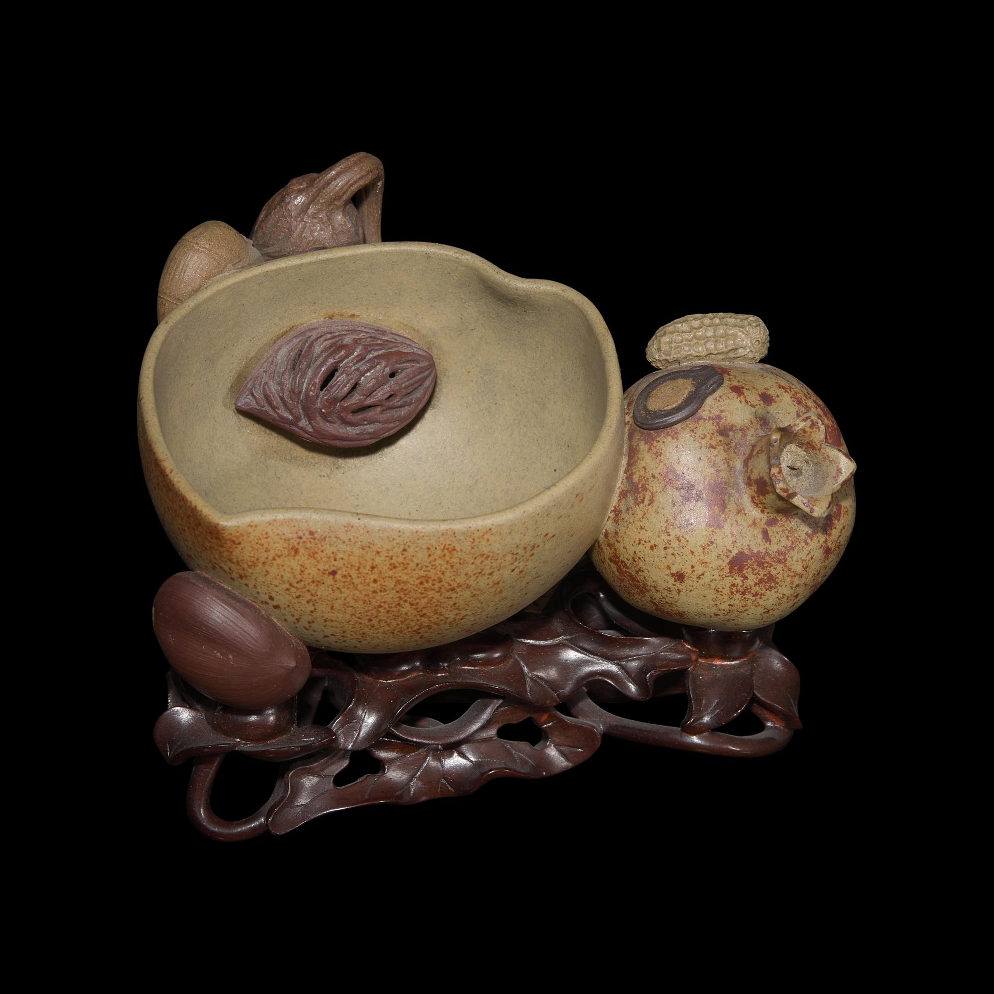 A Rare Chinese Yixing 'Peach and Pomegranate' Coupe Inscribed 'Chen Minyuan Zuo' and Carved Wood Stand 陳鳴遠款段泥紫砂桃榴杯