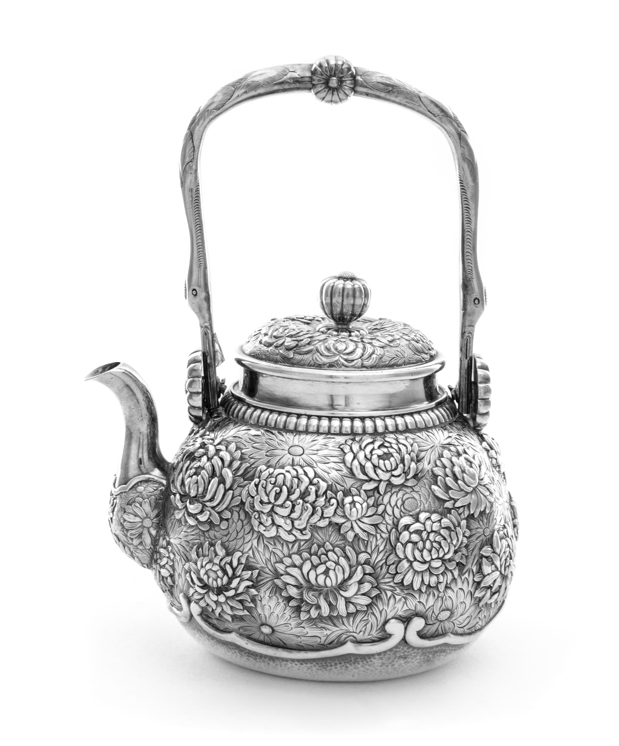 A Chinese Export Silver Teapot, , the body of globular form, finely chased with blooming chrysanthemums, having a curved side spout and
