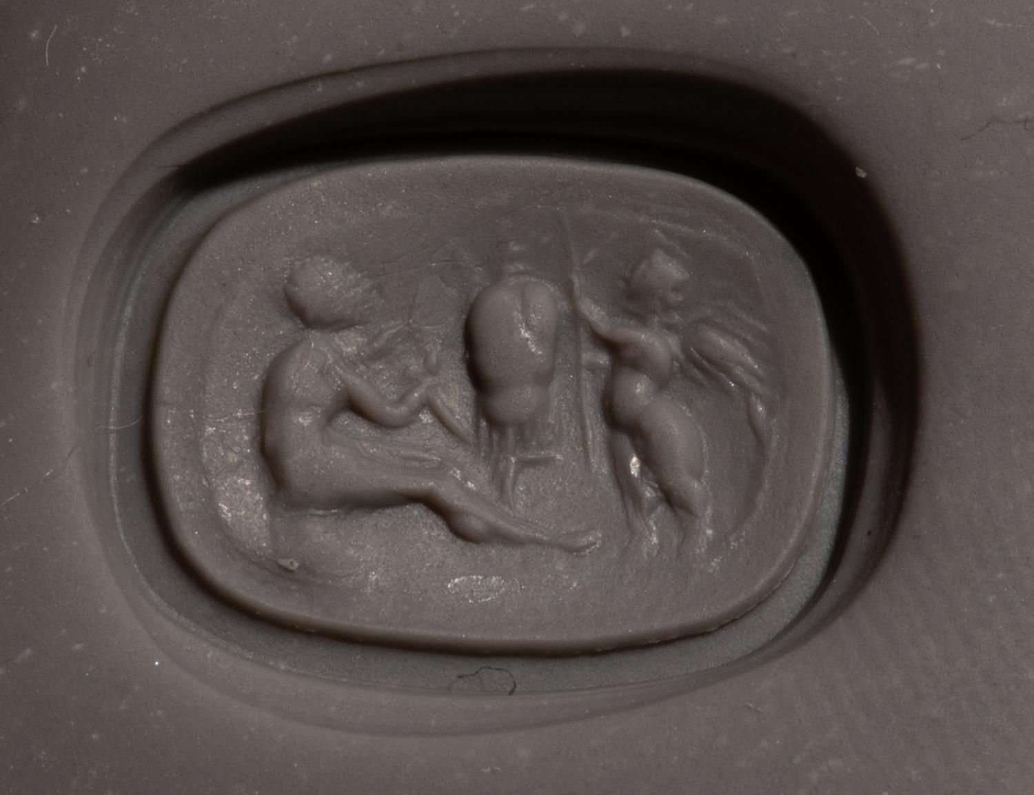 A Roman Carnelian Ring Stone with the God Eros Beside a Tropaion — Set in a gilt-copper ring