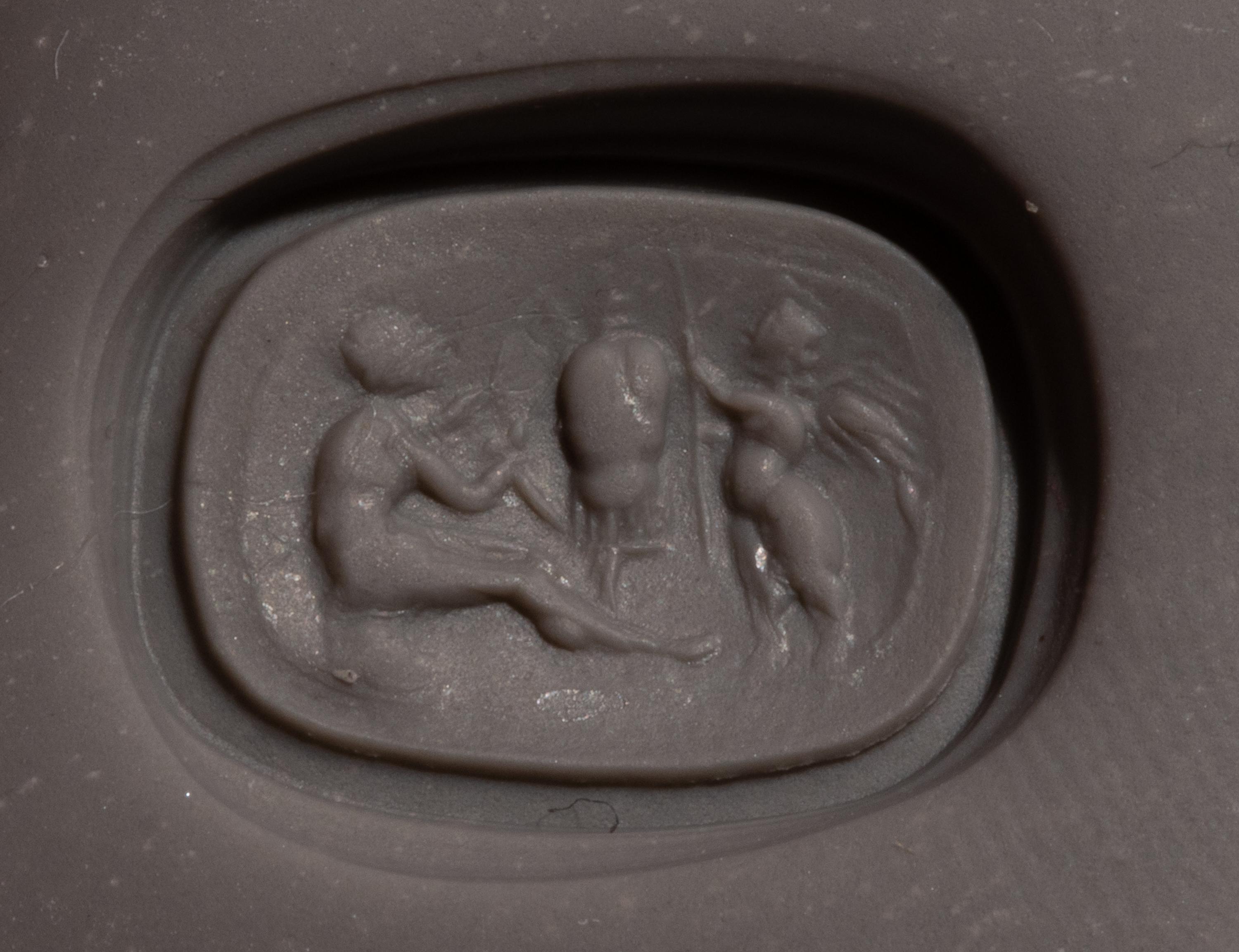 A Roman Carnelian Ring Stone with the God Eros Beside a Tropaion — Set in a gilt-copper ring