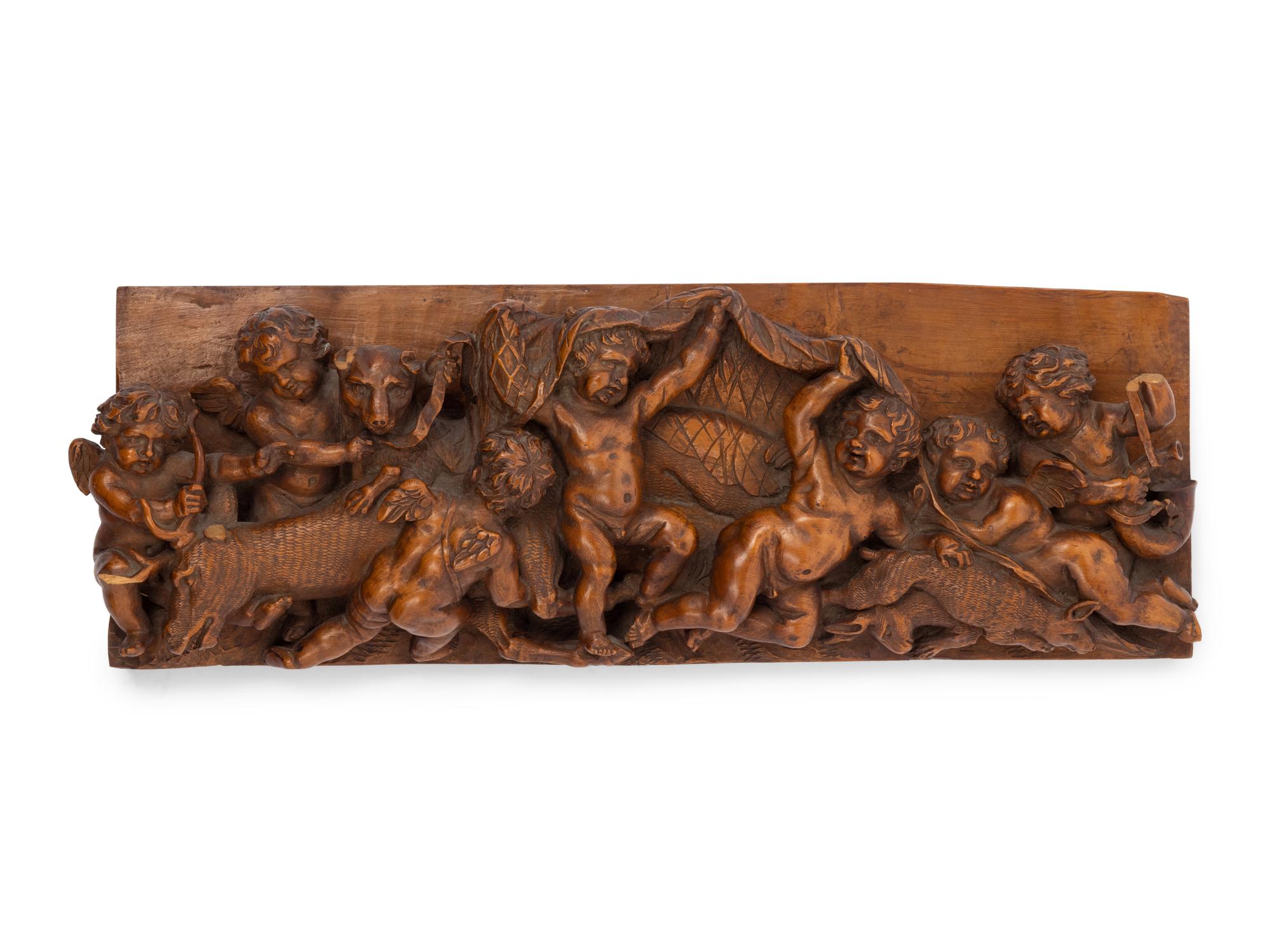 A Continental Carved Wood Plaque with Reveling Putti