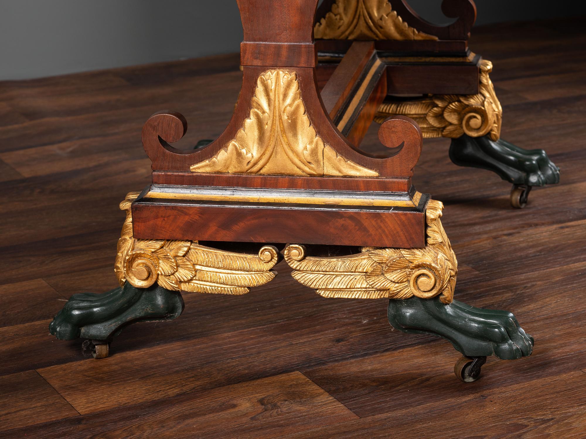 A Classical Parcel Gilt and Ebonized, Figured Mahogany Paw-Foot Drop-Leaf Table