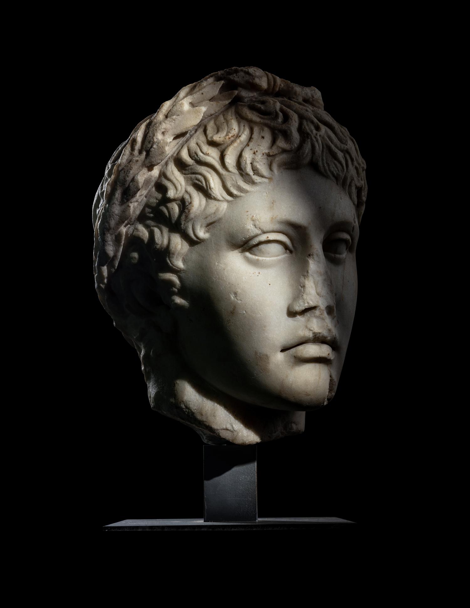 A Roman Marble Head of a Youth Wearing a Laurel Wreath