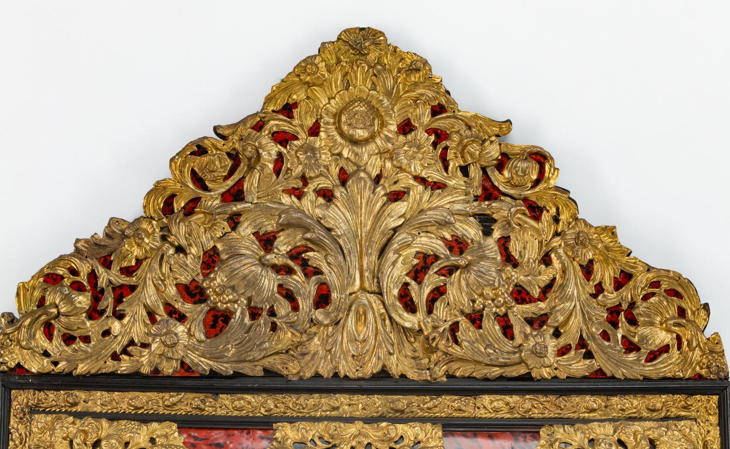 A Flemish Baroque Style Repouséed Brass, Simulated Tortoise and Ebonized Wood Mirror