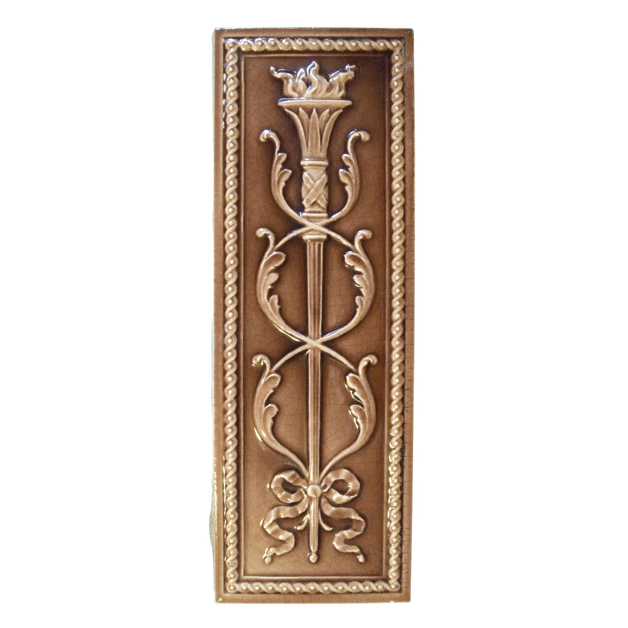 A Torch and Wreath Decorated Glazed Tile 6" W x 1" D x 18" H — United States, Early 20th Century