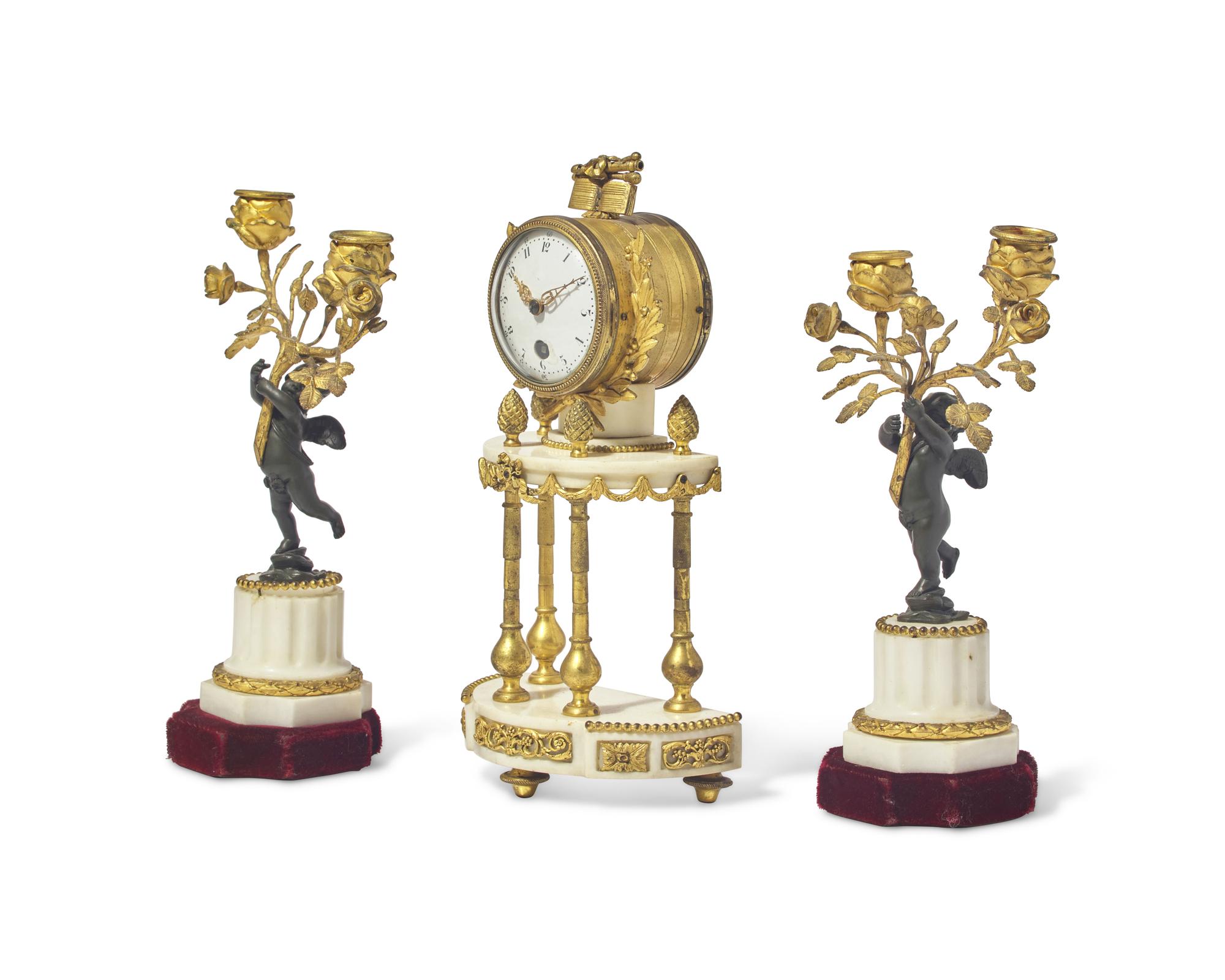 A Louis XVI Style Gilt and Patinated Bronze Mounted White Marble Three-Piece Clock Garniture