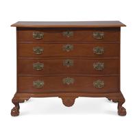 A Chippendale Figured and Shell-Carved Mahogany Reverse-Serpentine Chest of Drawers