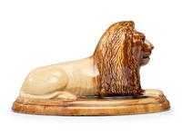 A Yellowware Recumbent Lion Figure