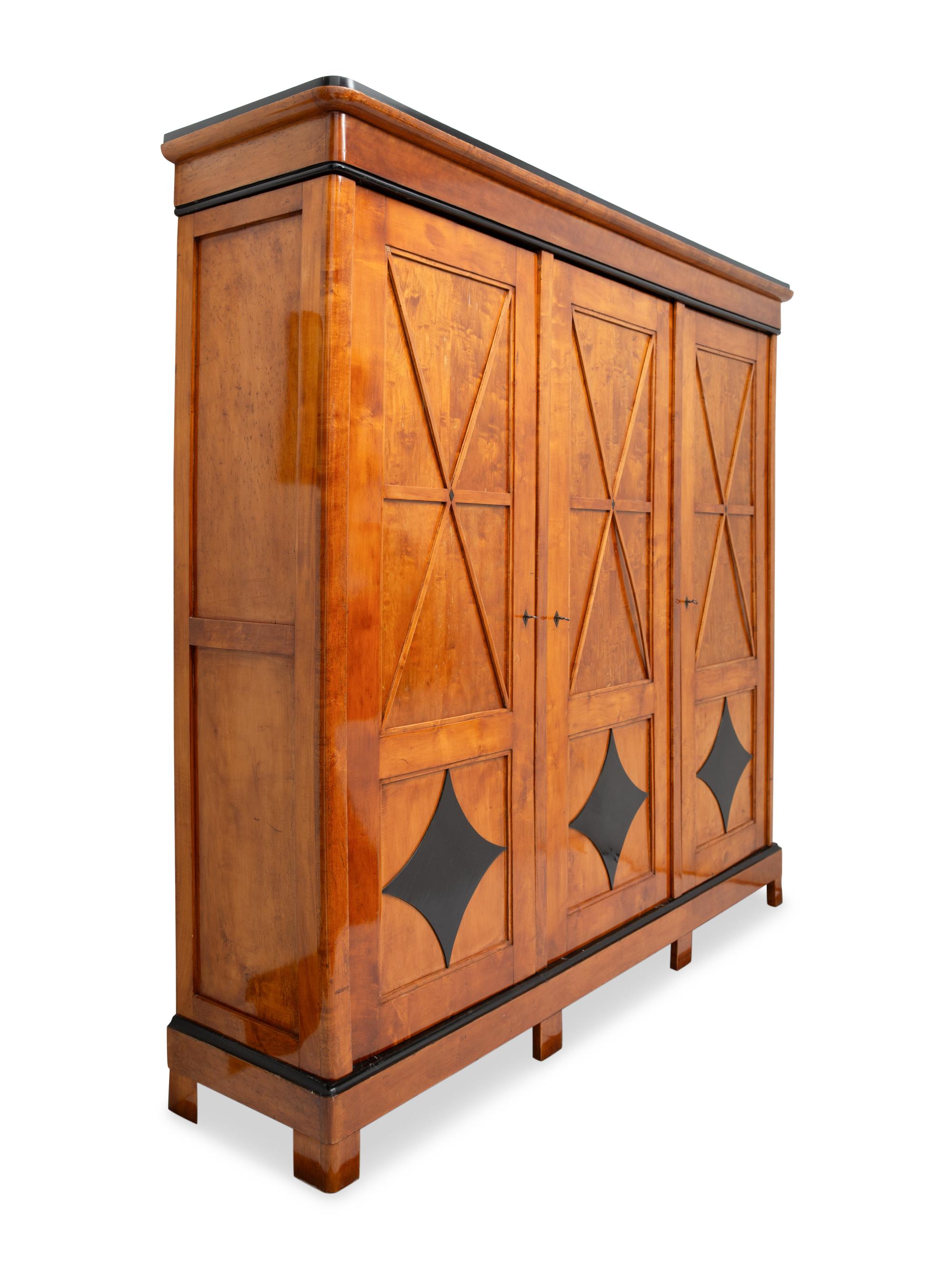 A Biedermeier Part-Ebonized Maple Three-Door Armoire