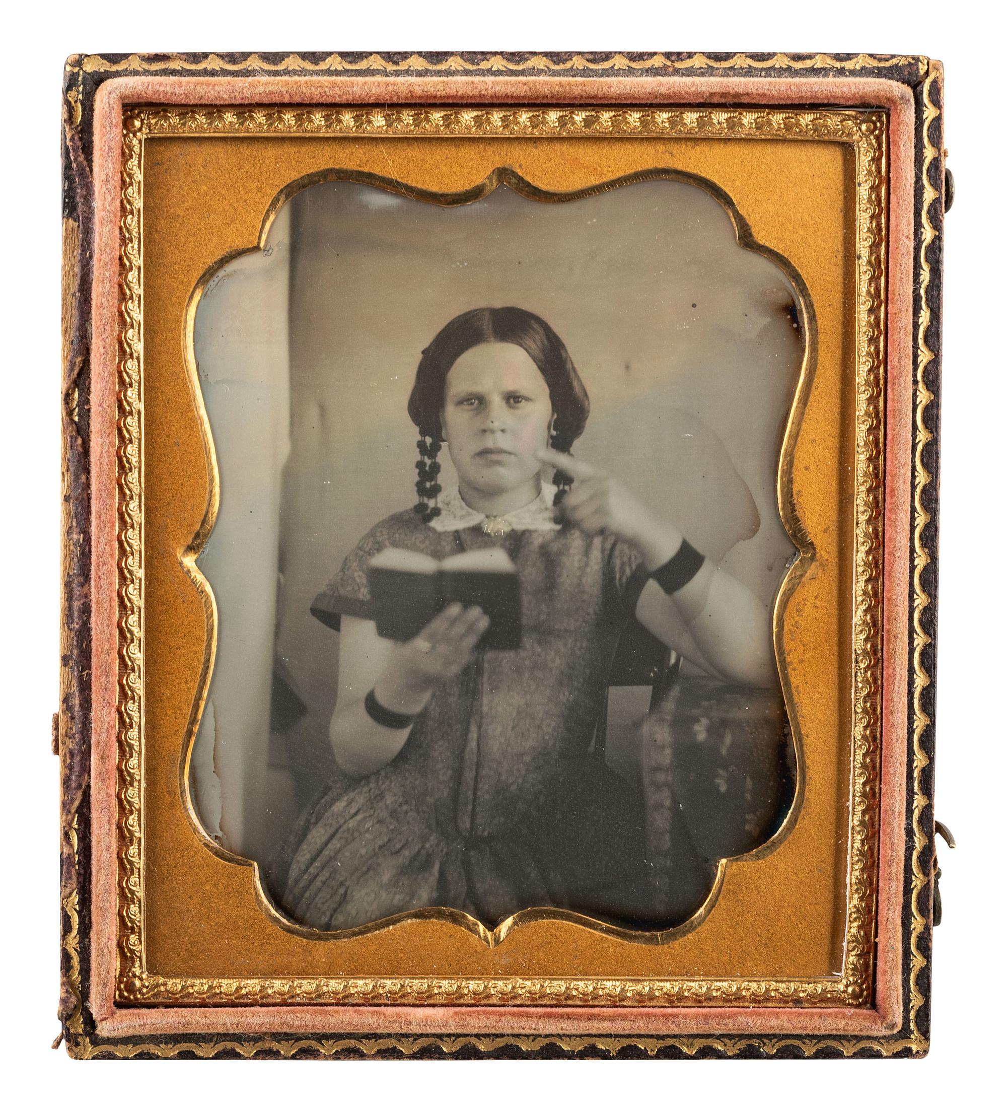 [EARLY PHOTOGRAPHY]. Sixth plate daguerreotype of a teenage girl making a point while reading a book.