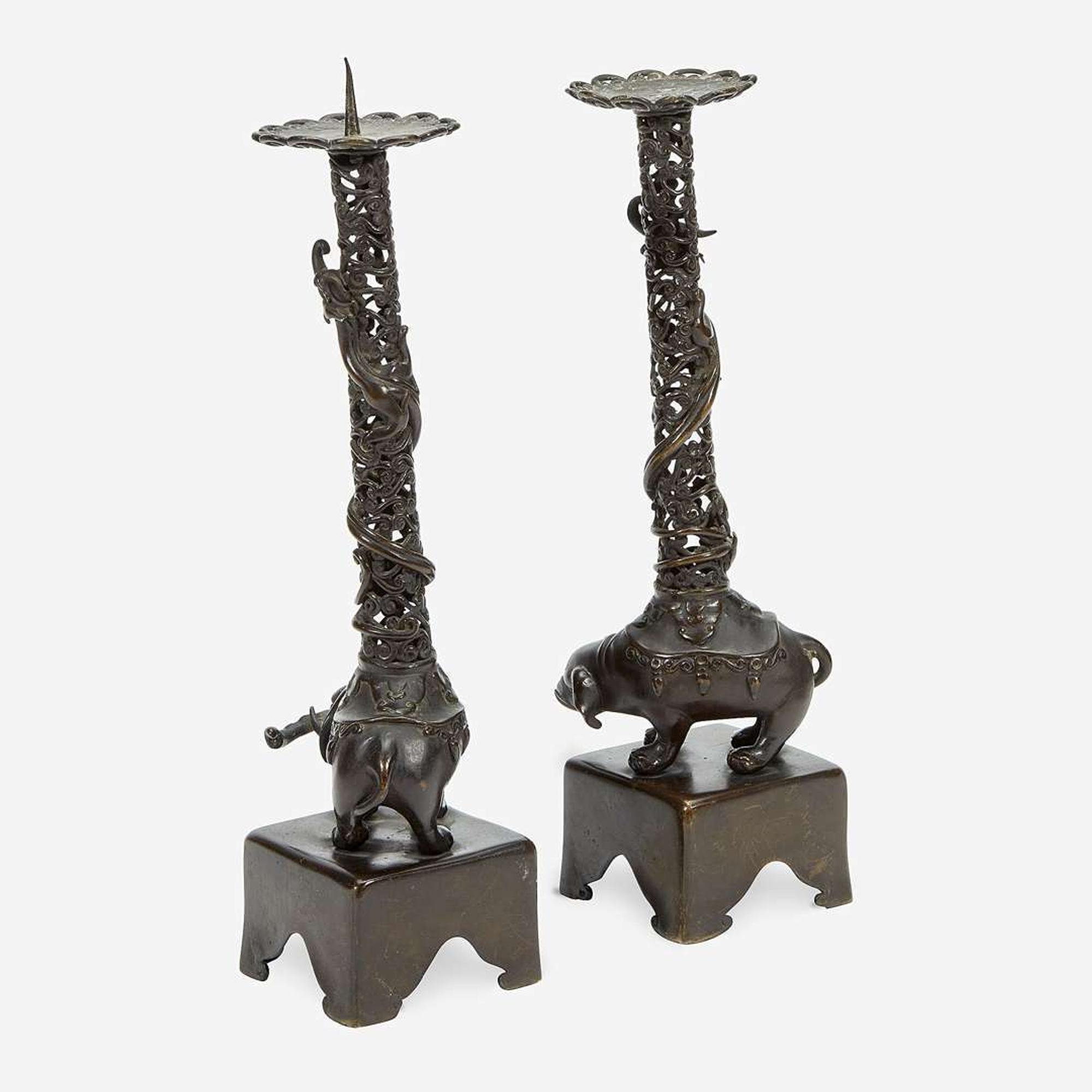 A pair of Japanese "Elephant and Dragon" patinated bronze openwork pricket candlesticks Edo period, 18th/early 19th Century