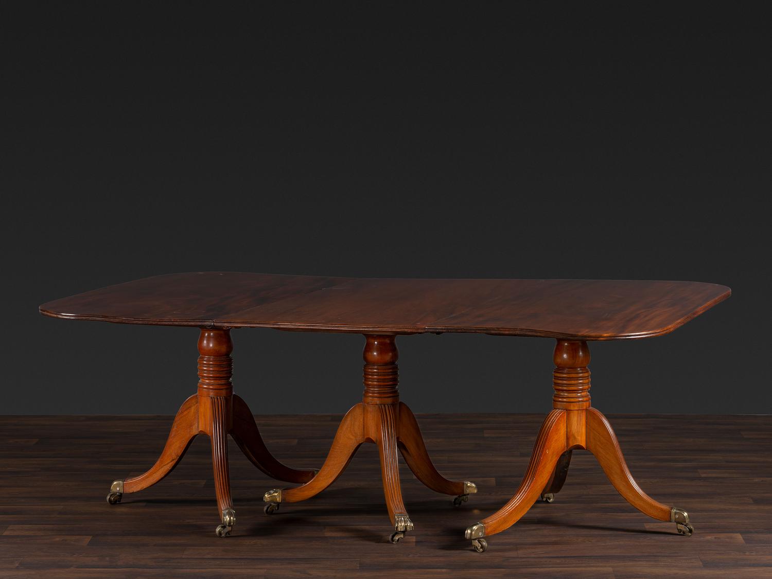 A Late Chippendale Flame Mahogany Triple Pedestal Dining Table