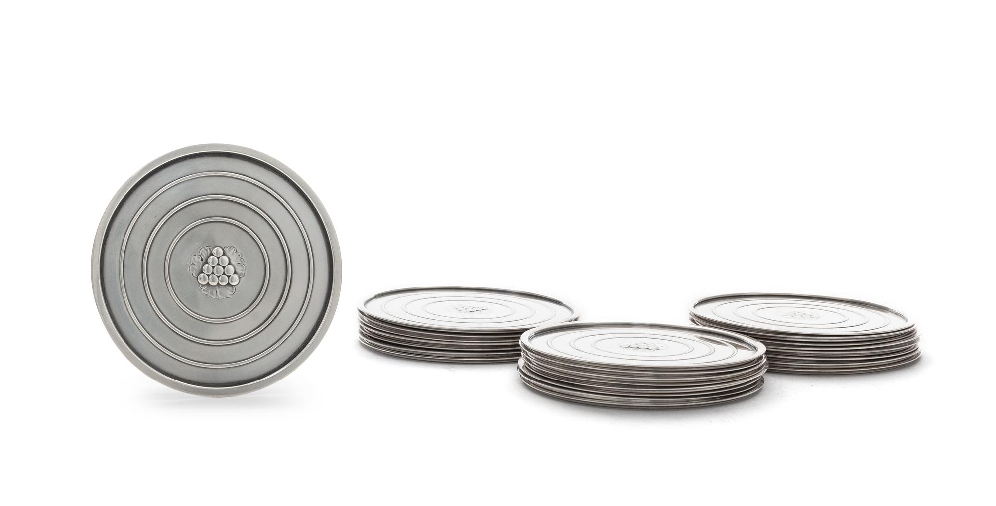 A Set of Twenty-Four Danish Silver Coasters, Georg Jensen, Copenhagen, Most 1945-77, no. 193A, circular with raised edge, center chased