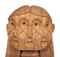 A Carved Wood Sculpture of a Three-Faced Man