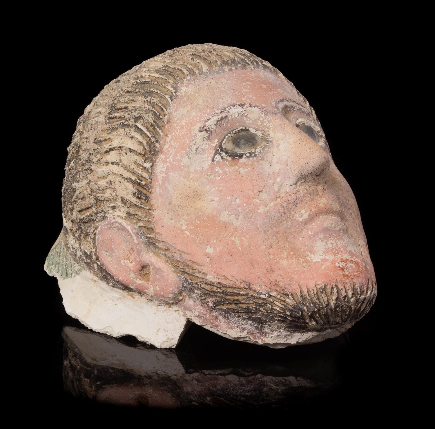 A Romano-Egyptian Plaster Mummy Mask Height 9 1/2 inches. — CIRCA 2ND CENTURY C.E.